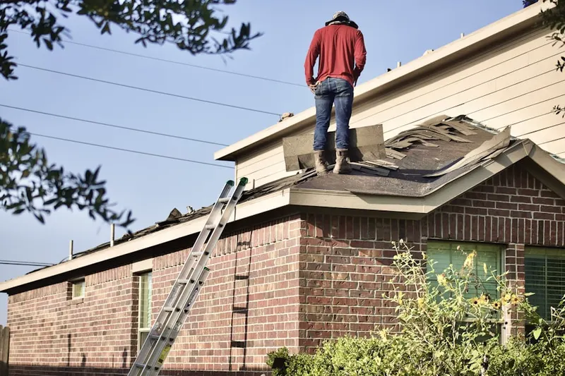 Professional roofer working on a residential roof in Green Village